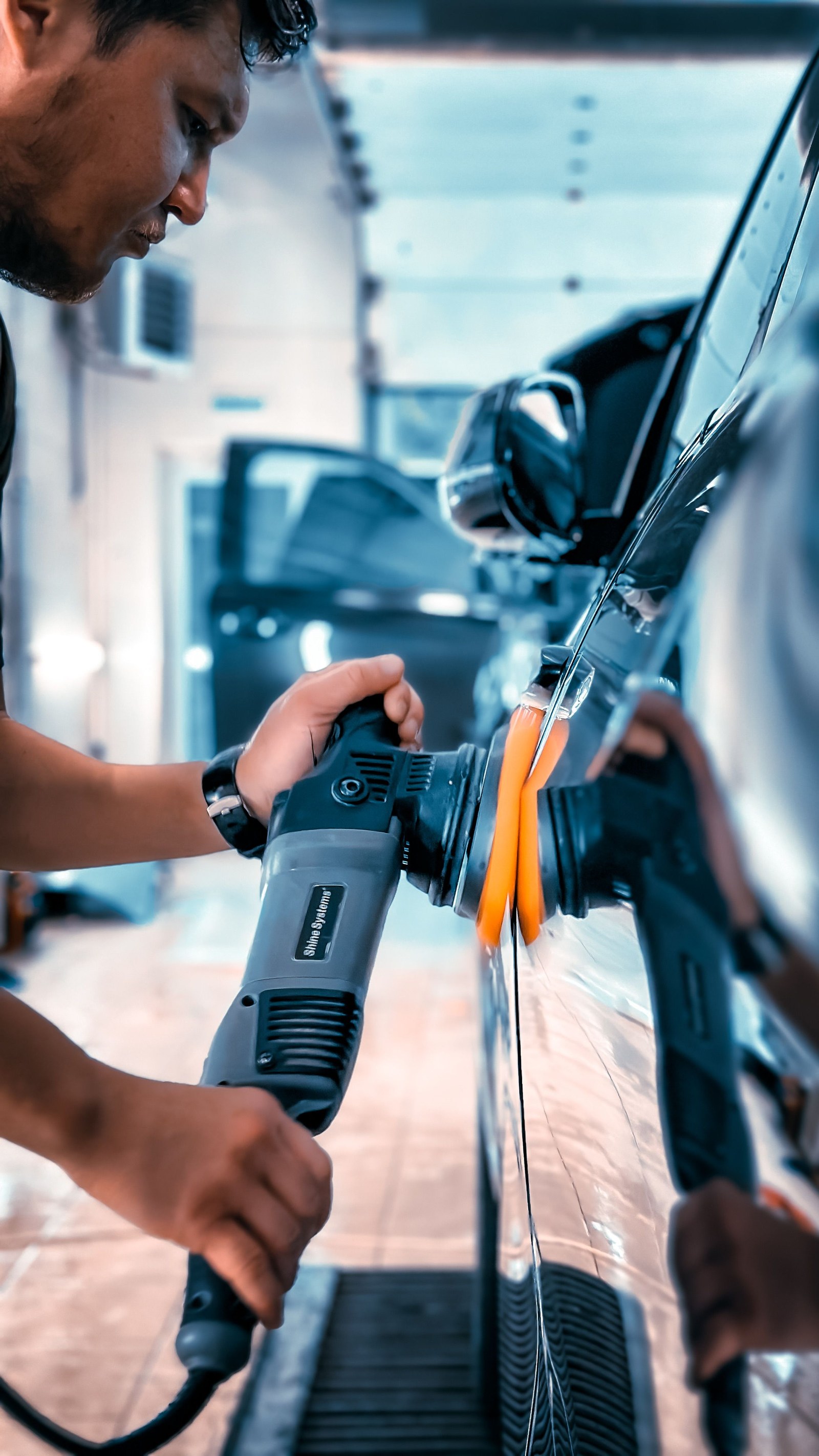 Technician polishing a vehicle ahead of a ceramic coating application